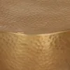 A close-up view of the hammered brass surface of a round table. Náhled obrázku produktu