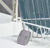 A close-up of a steel wool scrubber next to a dish rack with blue plates. Anteprima dell’immagine prodotto