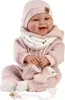 A baby doll dressed in pink clothing, sitting and holding a pacifier. Podgląd zdjęcia produktu