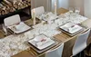 A dining table set for a meal with plates, cutlery, glasses, and candles. Produktbild-Vorschau