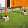 Two wooden posts are anchored to concrete blocks on a grassy lawn in front of a building with orange siding. Produktbild-Vorschau