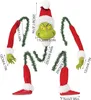 The image shows the disassembled parts of a Grinch-themed Christmas tree decoration, including its head, arms, and legs, with measurements indicated. Produktbild-Vorschau