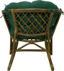 The back view of a rattan chair with a green cushion. Anteprima dell’immagine prodotto
