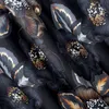 A close-up view of a dark floral pattern with metallic accents. Produktbild-Vorschau