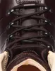A close-up view of the lacing system on a brown leather boot. Voir les images du produit