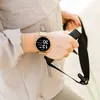A person's wrist wearing a smartwatch while holding exercise equipment. Produktbild-Vorschau