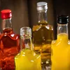 Four small glass bottles filled with colorful liquids, arranged in a close-up shot. Produktbild-Vorschau