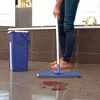 A person is mopping a tiled floor in a bathroom with a blue mop and bucket. Anteprima dell’immagine prodotto