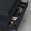 An open drawer of a dark gray vanity cabinet, filled with various cosmetic and personal care items. Anteprima dell’immagine prodotto