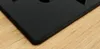 A close-up view of the corner of a black gas hob resting on a wooden surface. Anteprima dell’immagine prodotto