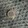 A close-up of bubble wrap with a one euro coin placed on top. Produktbild-Vorschau