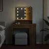 A vanity table with a lighted mirror and a stool in a bedroom setting. Náhled obrázku produktu