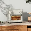 A cream-colored mini oven is shown on a kitchen counter, with food inside. Produktbild-Vorschau