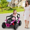 A young child is riding in a pink toy car while a woman walks beside them in front of a large house. Anteprima dell’immagine prodotto