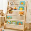 A children's bookshelf filled with books and toys in a nursery or playroom setting. Anteprima dell’immagine prodotto