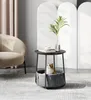A cat sits in a basket under a round side table in a living room. Produktbild-Vorschau