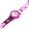 A close-up, angled view of a child's watch with a pink glittery bezel and a fabric strap featuring unicorns and stars. Produktbild-Vorschau