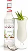 A bottle of Monin Coconut syrup next to a cocktail and coconut pieces. Podgląd zdjęcia produktu