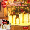 Christmas gift boxes with lights in a festive setting with a Christmas tree and lantern. Podgląd zdjęcia produktu