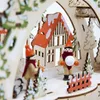 A close-up of a wooden Christmas decoration depicting a winter scene with figures and a house. Produktbild-Vorschau