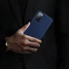 A person in a dark suit holds a dark blue phone case. Podgląd zdjęcia produktu