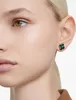 Close-up of a woman's ear wearing a green clover-shaped stud earring. Produktbild-Vorschau