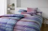 A neatly made bed with striped bedding in a bedroom setting. Produktbild-Vorschau