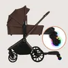A brown stroller with a detachable buggy board, shown with a close-up of a wheel with colorful lights. Náhľad obrázku produktu