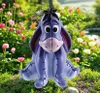 A figurine of Eeyore from Winnie the Pooh sitting in a garden with flowers. Produktbild-Vorschau