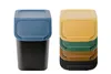 Two stacks of colorful trash cans with lids, presented against a white background. Produktbild-Vorschau
