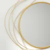 A close-up of a round mirror with a gold metal frame and decorative gold wire accents. Náhľad obrázku produktu