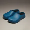 A pair of blue clogs on a plain background. Produktbild-Vorschau