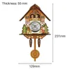 A wooden cuckoo clock with decorative figures and a pendulum. Náhľad obrázku produktu