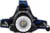 A close-up, front-facing view of a black LED headlamp with a silver bezel around the lens and blue and black straps. Náhľad obrázku produktu