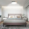A bedroom with a bed, nightstands, and a ceiling lamp. Voir les images du produit
