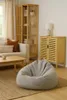 A living room scene with a sofa, bookshelf, cabinet, and a beanbag chair. Produktbild-Vorschau
