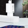 A white Xiaomi USB power adapter is plugged into a white power strip, with a smartphone charging cable connected to a smartphone in the foreground. Podgląd zdjęcia produktu