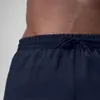 Close-up of the waistband and upper part of navy blue shorts worn by a person. Produktbild-Vorschau