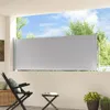 A balcony with a retractable side awning extended, providing privacy and shade. There is outdoor furniture present. Anteprima dell’immagine prodotto