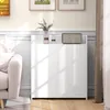 A white cabinet with decorative items on top, next to a sofa, in a room with natural light. Náhľad obrázku produktu