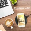 A desk scene with a laptop, coffee, and a phone charging wirelessly. Produktbild-Vorschau