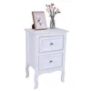 A white two-drawer nightstand with decorative legs, a framed picture, and a vase of flowers on top. Anteprima dell’immagine prodotto