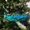 A decorative peacock ornament is attached to a Christmas tree branch. Produktbild-Vorschau