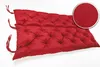 A red tufted bench cushion with ties on a white background. Produktbild-Vorschau