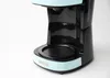 A close-up shot of a turquoise and black coffee maker. Anteprima dell’immagine prodotto