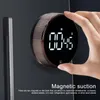 A hand is holding a magnetic digital timer against a dark surface. Produktbild-Vorschau