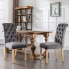 A dining room scene with two chairs in the foreground and a table and bookshelf in the background. Voir les images du produit