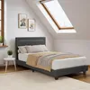 A bedroom with a bed, a skylight, and artwork on the wall. Náhled obrázku produktu
