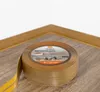 A roll of self-adhesive skirting board tape with a wood grain pattern is shown in the foreground, with a corner of a room featuring installed skirting boards in the background. Anteprima dell’immagine prodotto