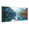A panoramic landscape photo of a lake with mountains and trees reflected in the water. Two small boats are docked at a wooden pier. Produktbild-Vorschau